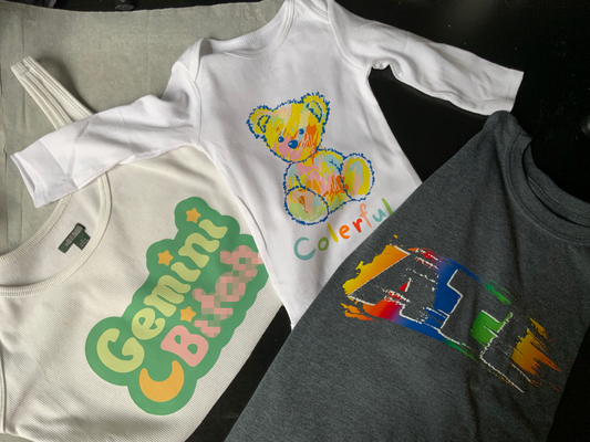 Three shirts, (l) ribbed cropped "Gemini B**", (m) baby onesie "colorful teddy bear", (r) charcoal "ATL" 